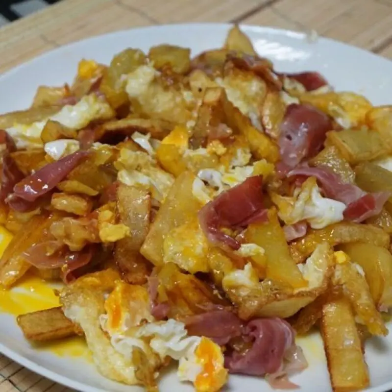Huevos rotos con patatas y jamón (150gr.)
